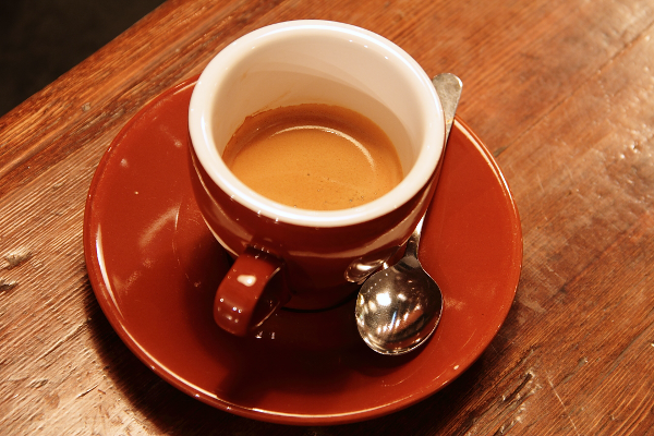 Input: a real photo of an espresso cup, saucer and teaspoon